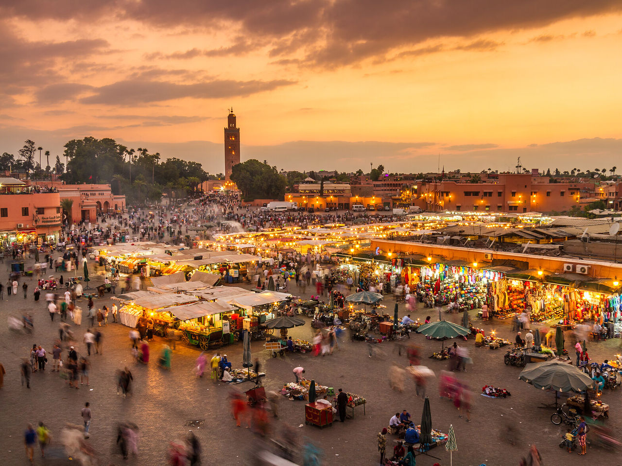 Vista desde arriba de la plaza principal del centro histórico de Marrakech, de noche, con tiendas y puestos iluminados