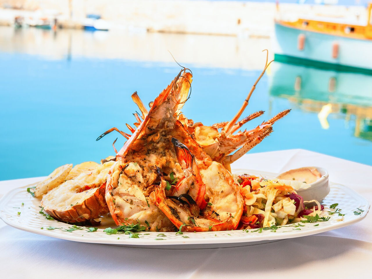 Pruebe los mariscos de la costa de Tánger, en un plato lleno de camarones a la parrilla con hierbas y el mar al fondo