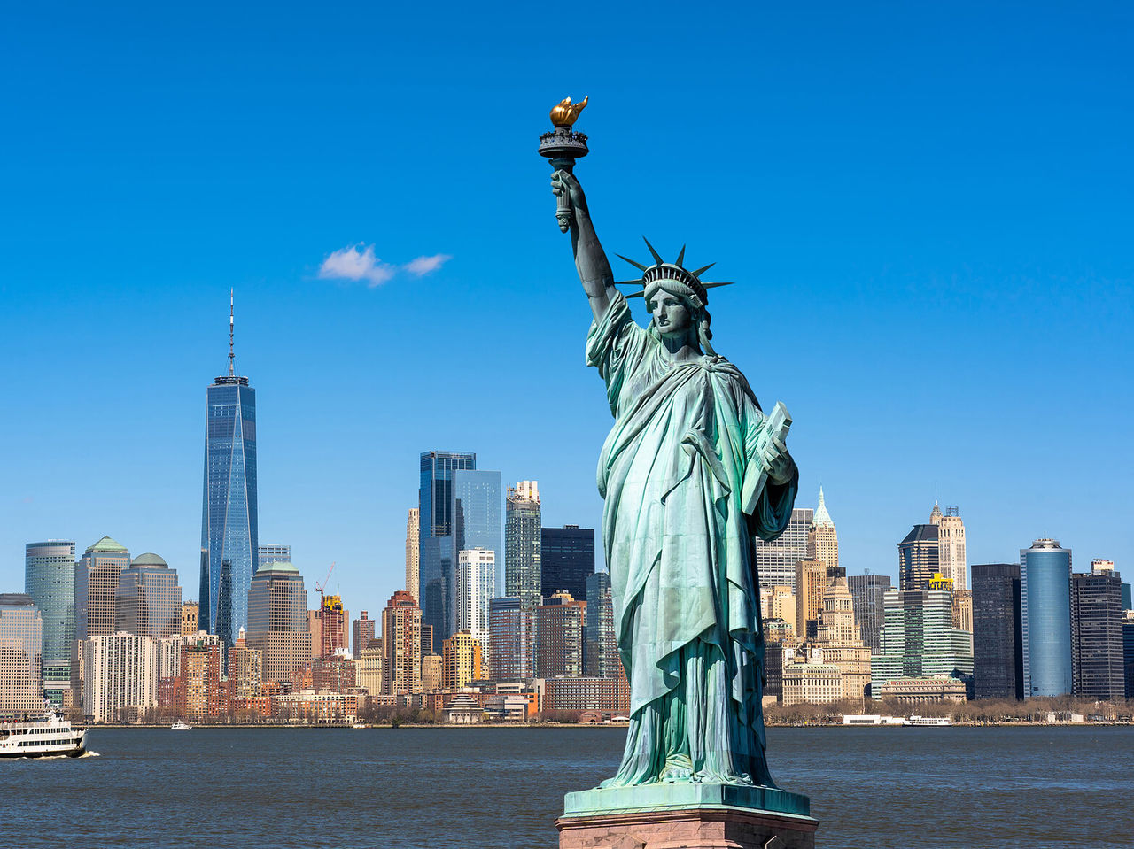 Paisaje urbano de Nueva York con la Estatua de la Libertad en primer plano y el horizonte de Nueva York como fondo