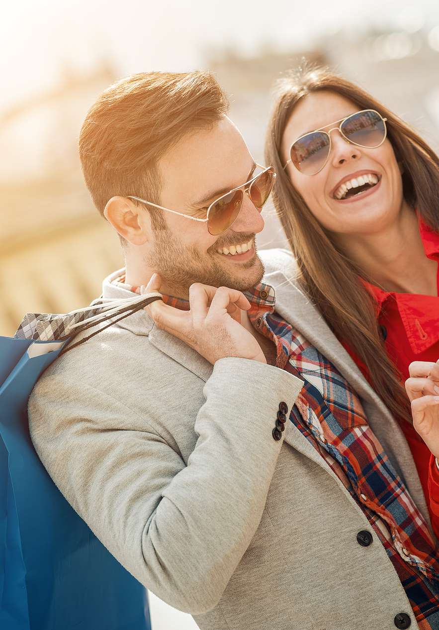 Pareja sonriente comprando en la Rua Oscar Freire, calle de lujo y boutiques elegantes en São Paulo