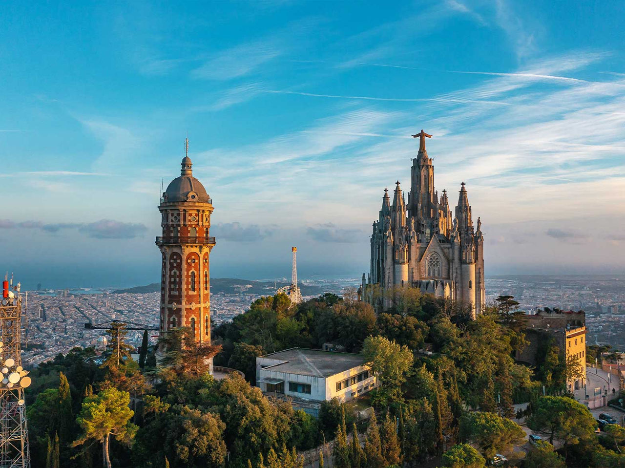 Vista del Templo del Sagrado Corazón de Jesús en el Tibidabo, rodeado de vegetación y con la ciudad de Barcelona al fondo