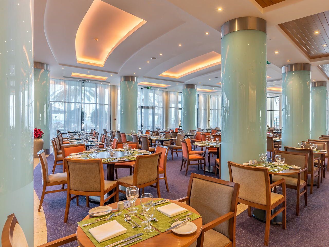El restaurante Atrium, del Hotel 5 Estrellas en Funchal, en Madeira, tiene un amplio salón con pilares azules y mesa