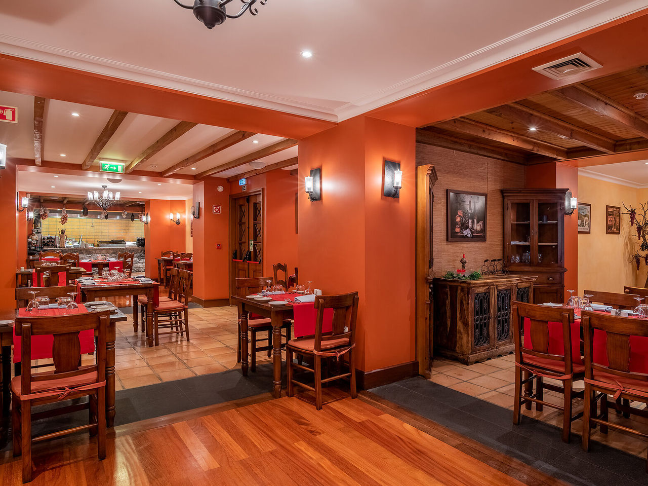 El restaurante Adega Madeirense del hotel romántico en Funchal, Madeira, tiene decoración antigua y paredes naranjas