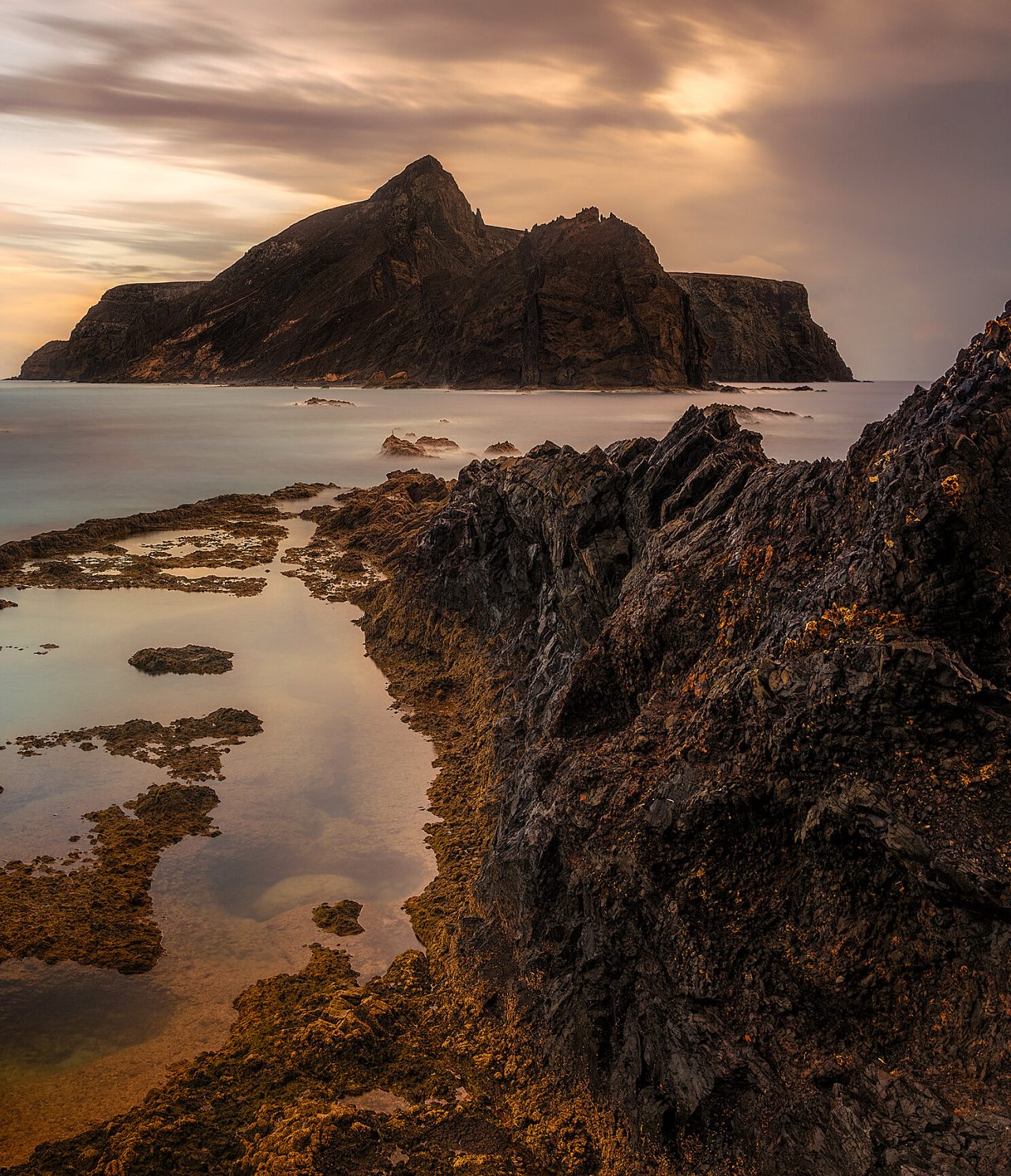 Vista de la costa rocosa de la isla de Porto Santo, Madeira, con una isla rocosa al fondo