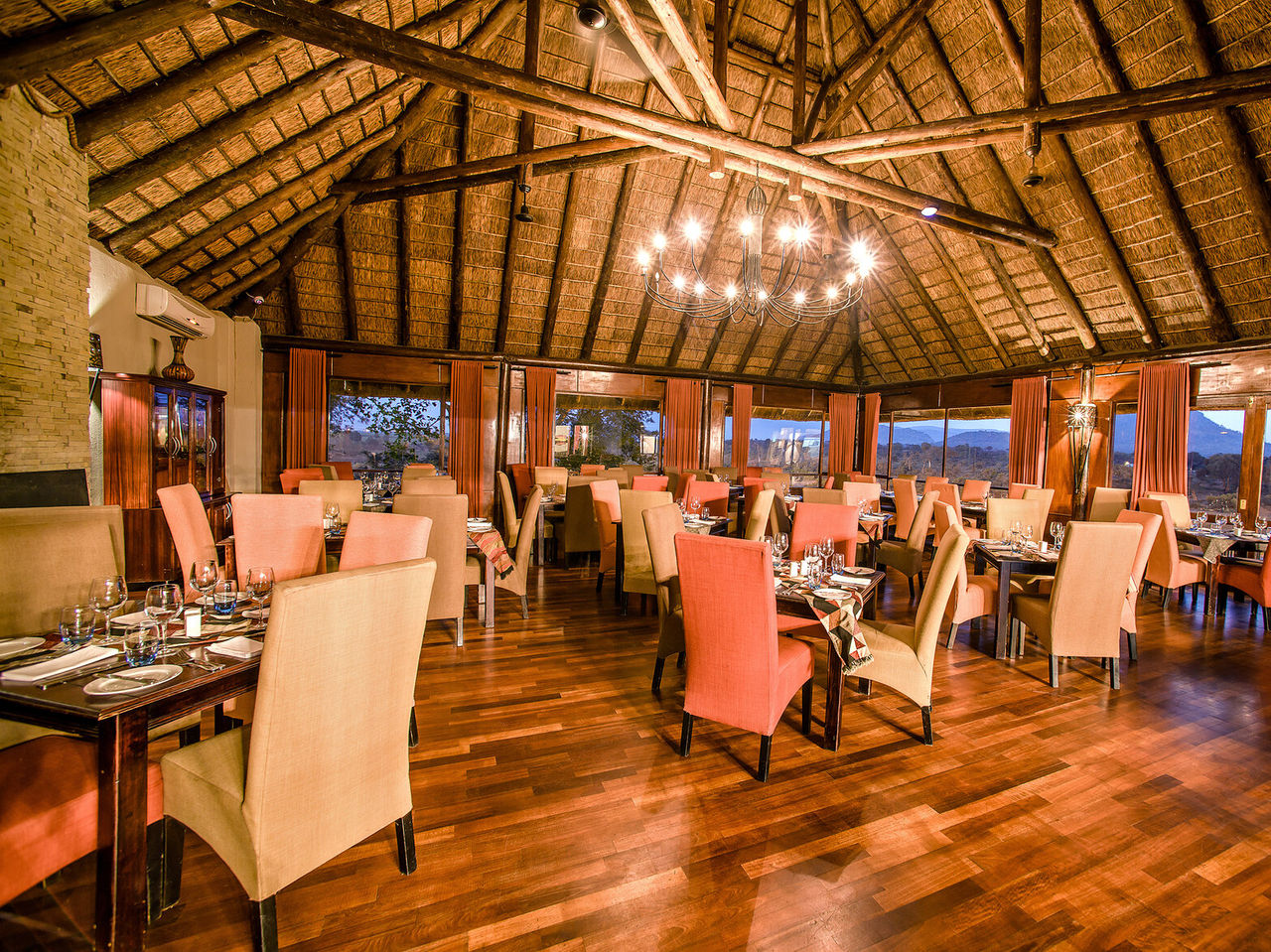 O restaurante Buhlebethu, do Hotel 4 Estrelas no Kruger Park, tem várias mesas e uma decoração típica africana