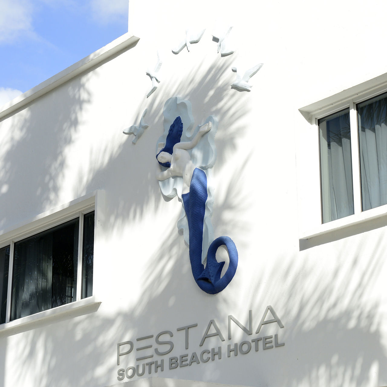 Fachada do Pestana Miami South Beach hotel, com uma escultura em destaque mostrando uma sereia e o número 1831