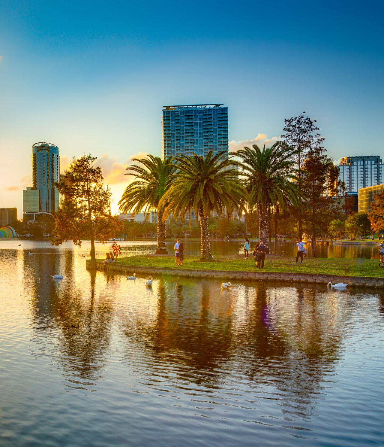 Vista panorâmica de Orlando, com um lago sereno onde o pôr do sol reflete-se nas águas tranquilas do lago