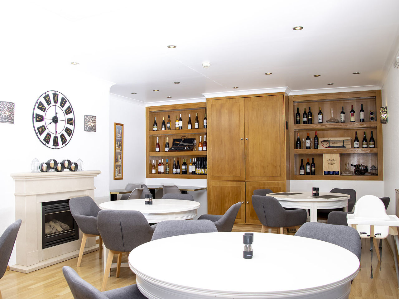 O restaurante Sal Tal, do Hotel 4 Estrelas no Carvoeiro, Algarve, tem mesas redondas e um armário com diversos vinhos