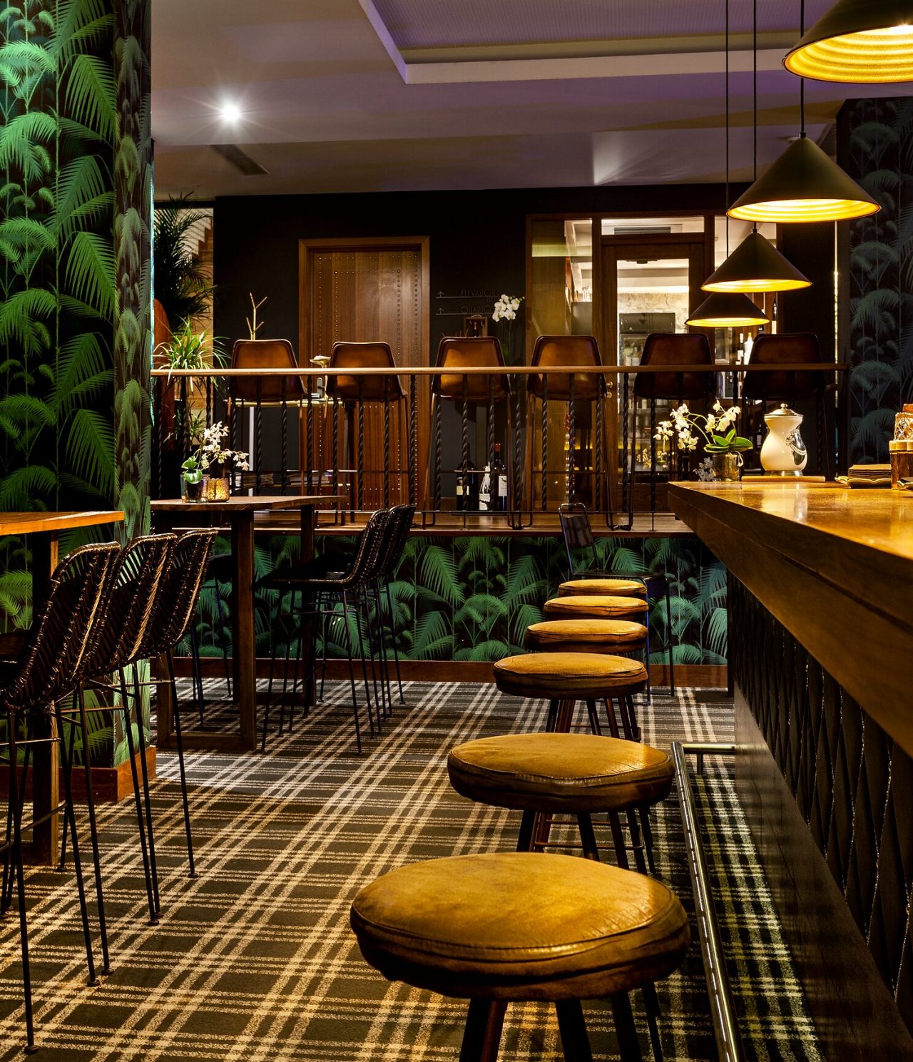 O Rib Bar, do Hotel 5 Estrelas no Centro do Porto,  tem um balcão com bancos altos e papel de parede tropical