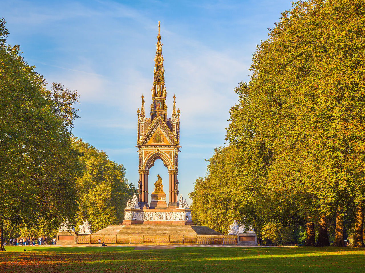Vista de um parque para o icónico Albert Memorial, com a sua estátua dourada central e detalhes esculpidos