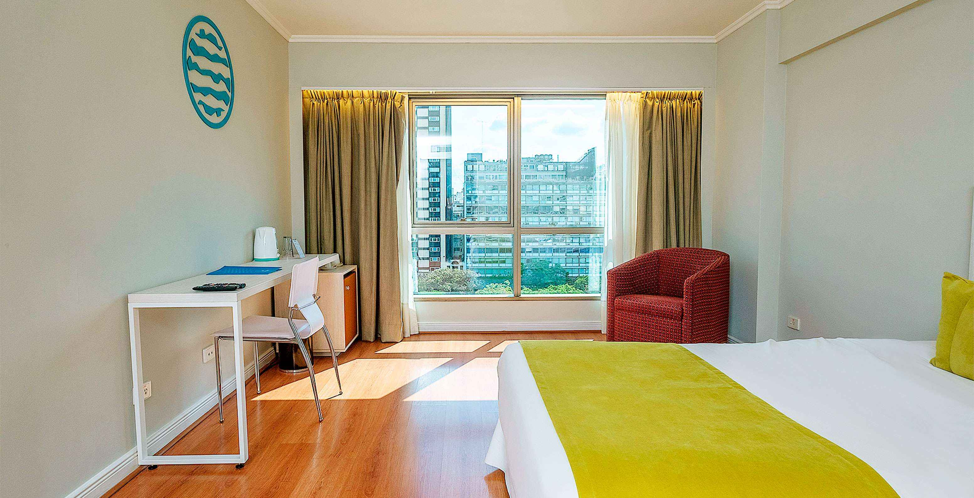 The Queen Superior at Pestana Buenos Aires has a double bed, a desk, and a chair