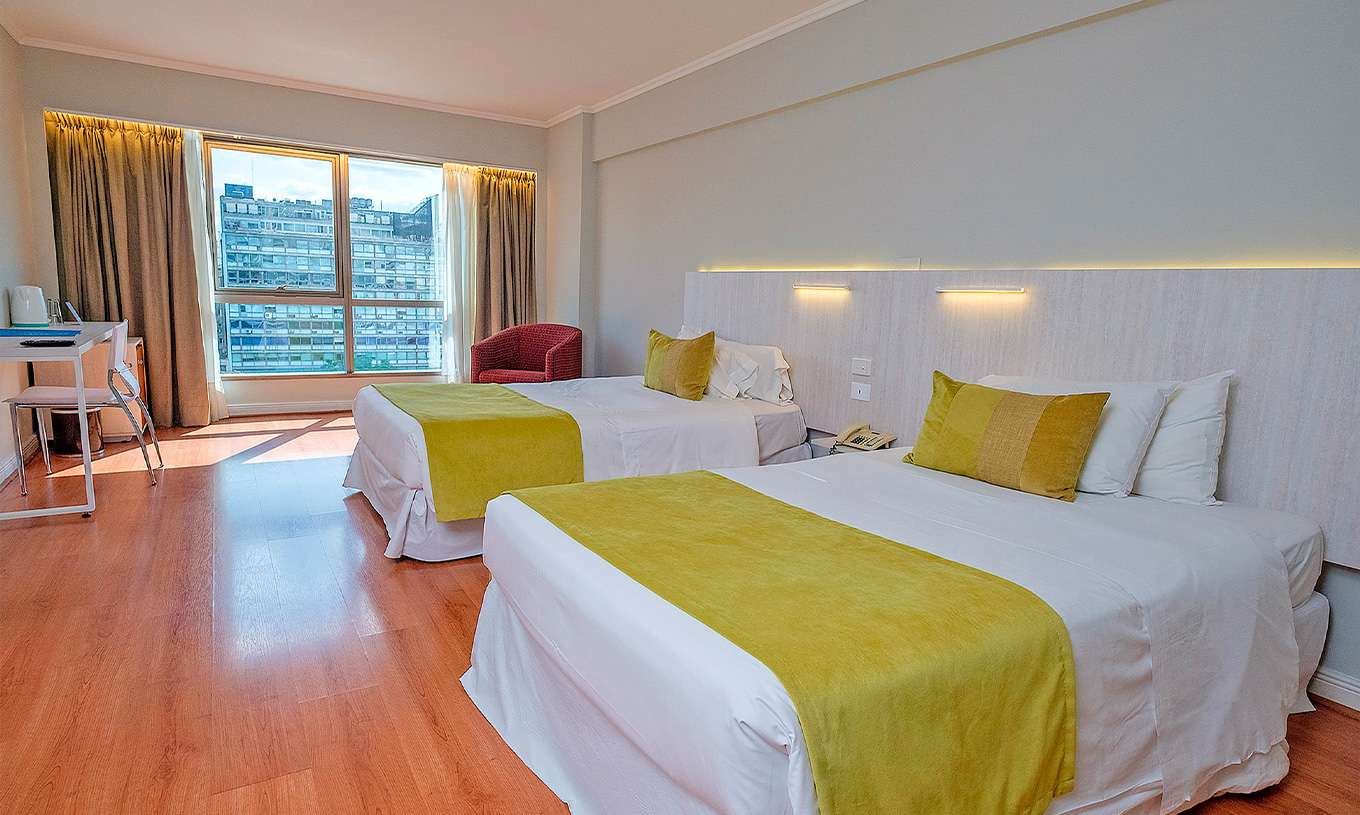 The Twin Superior at Pestana Buenos Aires has two single beds, a bedside table, and a chair