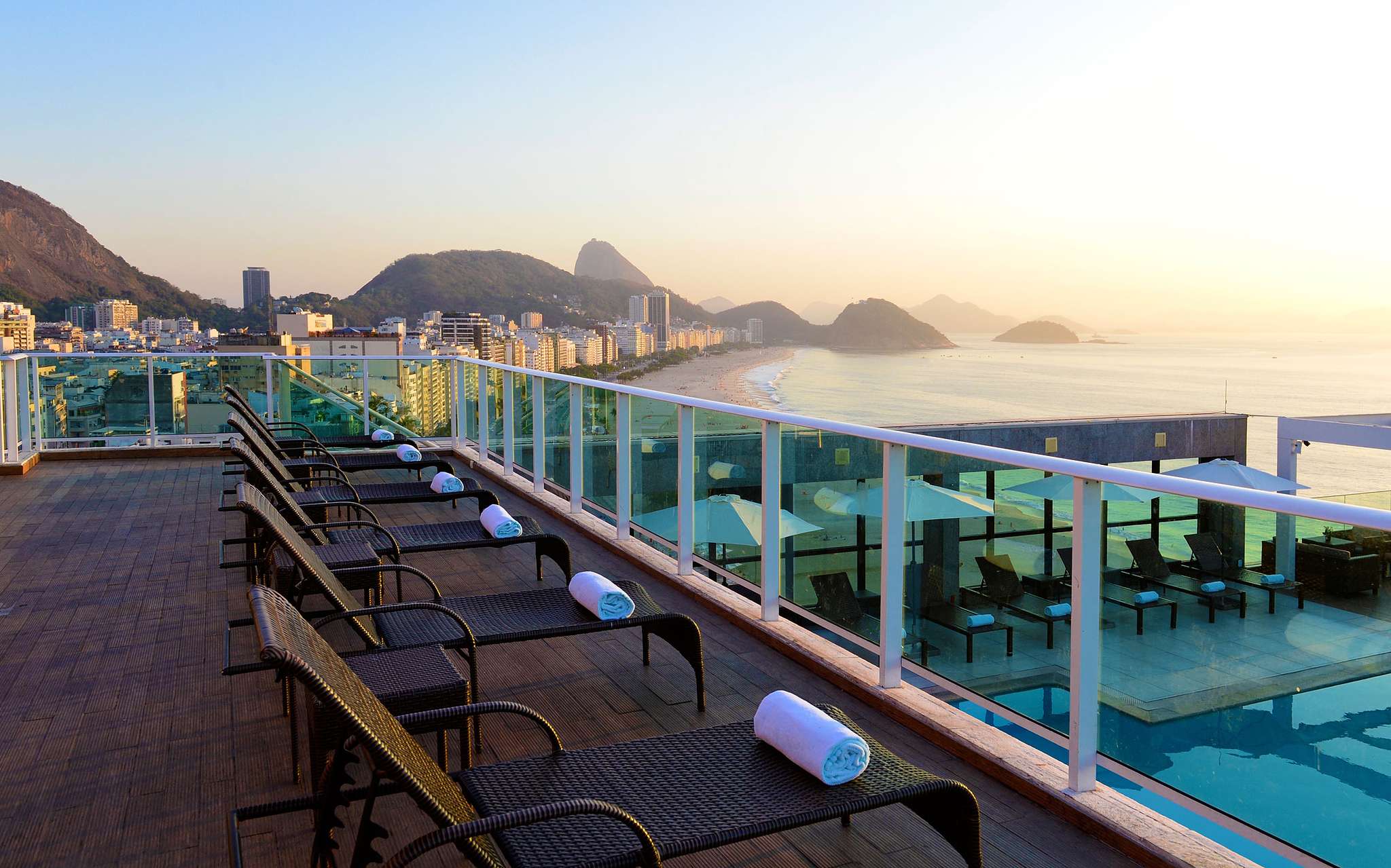 Rooftop of a 4-star hotel in Rio de Janeiro, with sun loungers with towels and a view of Copacabana Beach