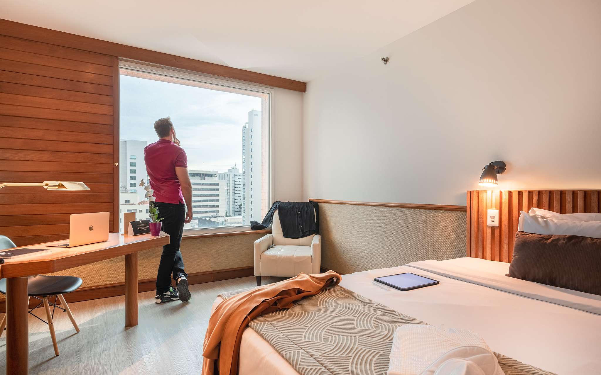 Man admiring the view from the window of a hotel room at Pestana São Paulo, a hotel in downtown São Paulo