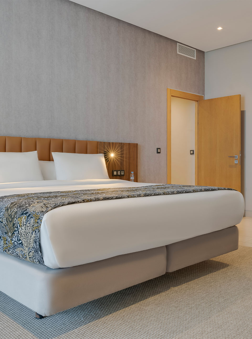 The Family Suite at Pestana Casablanca has a spacious bedroom with a double bed and modern decor