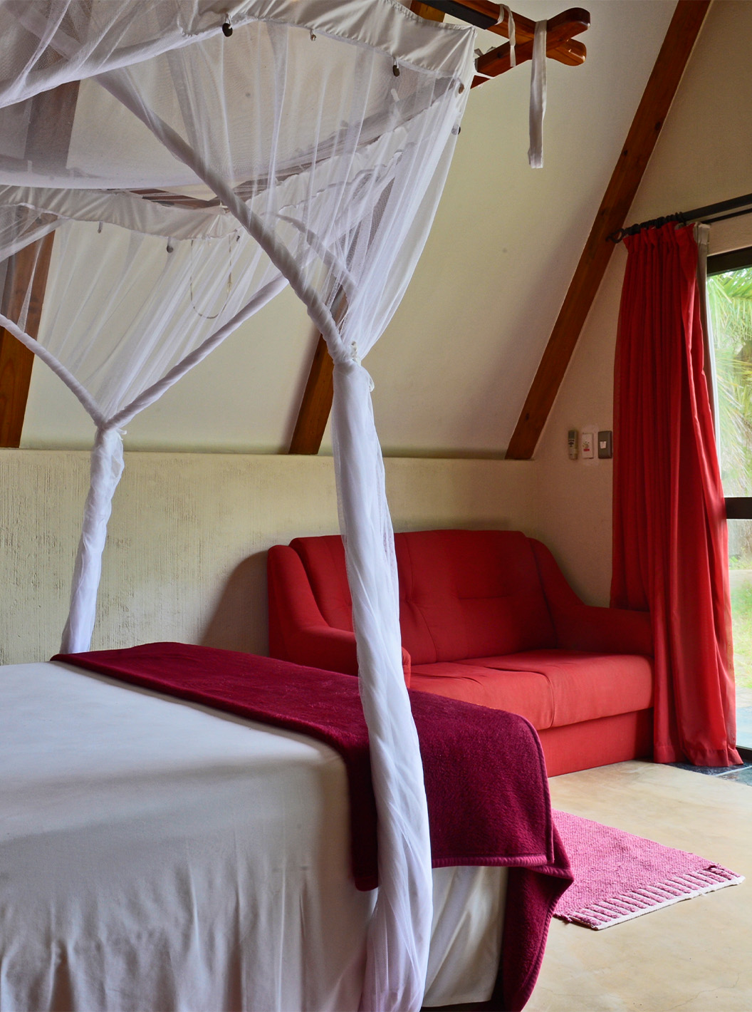 Bungalow Suite T2 at Pestana Bazaruto Lodge has a bed with canopy and garden view and a double sofa on the side