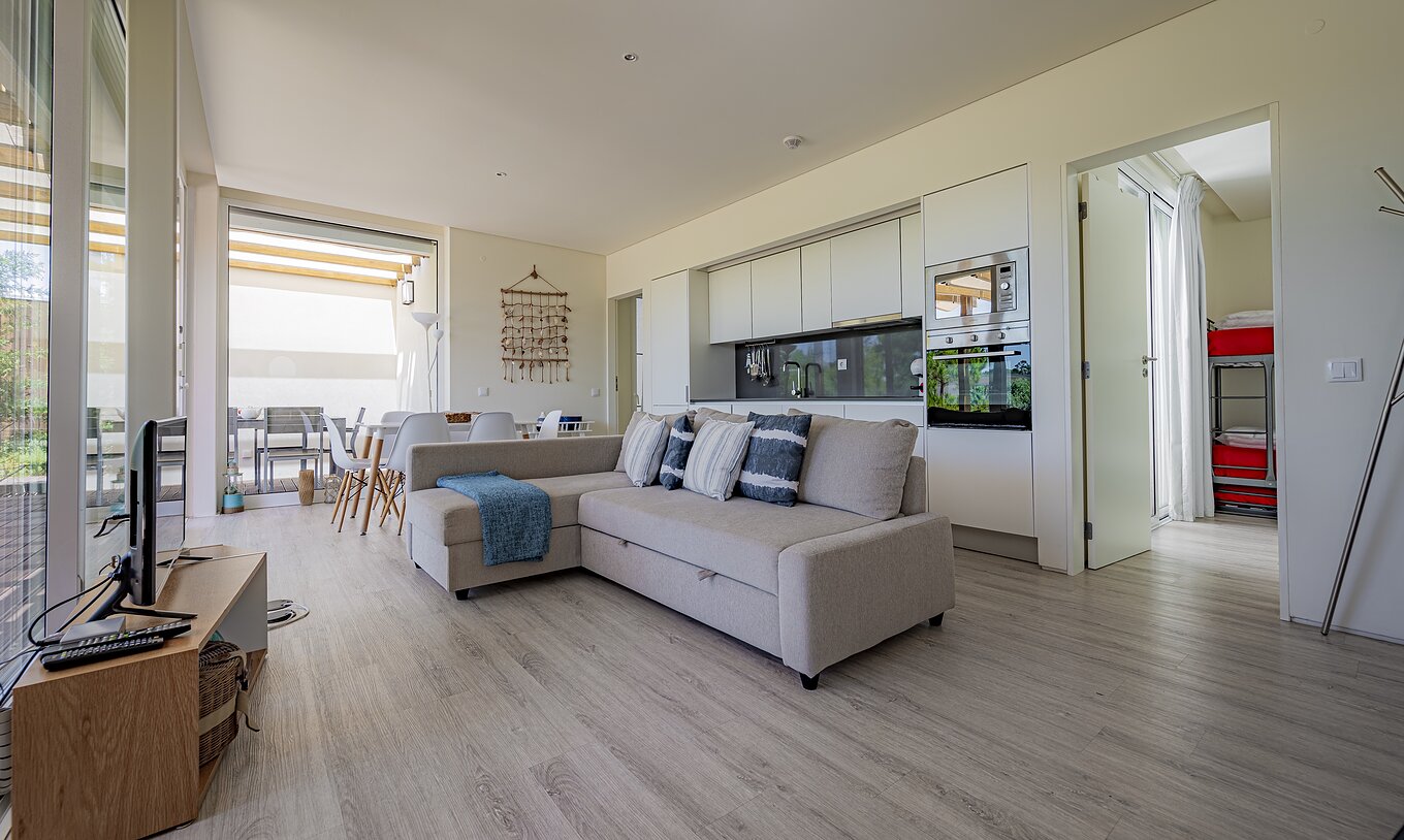 The Green Villa of Pestana Tróia Eco Resort has a room combined with the kitchen, with sofa, dining table, and television