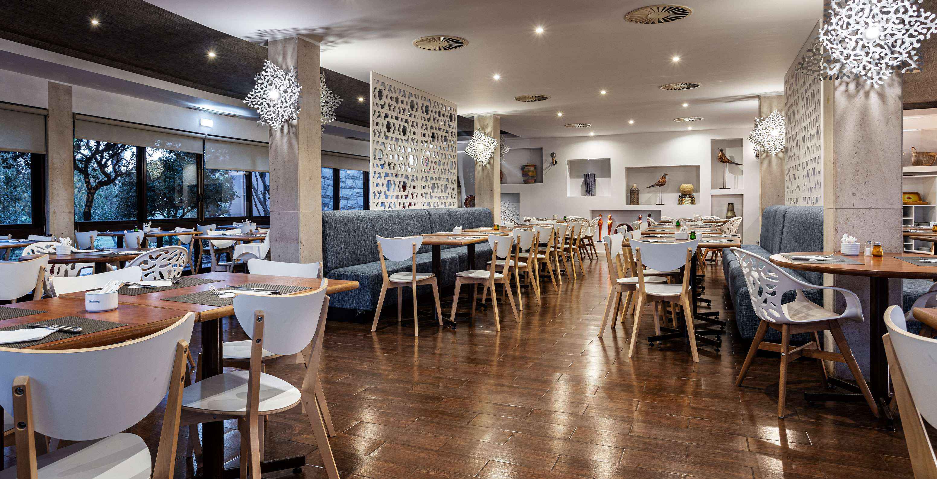 Spacious restaurant with several tables, chairs, and sofas for enjoying a meal