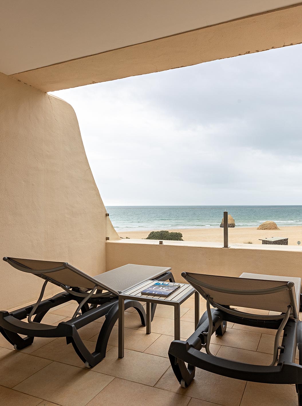 The Cliff Suite T1 at Pestana Alvor Praia has a balcony with two loungers and a view of the beach