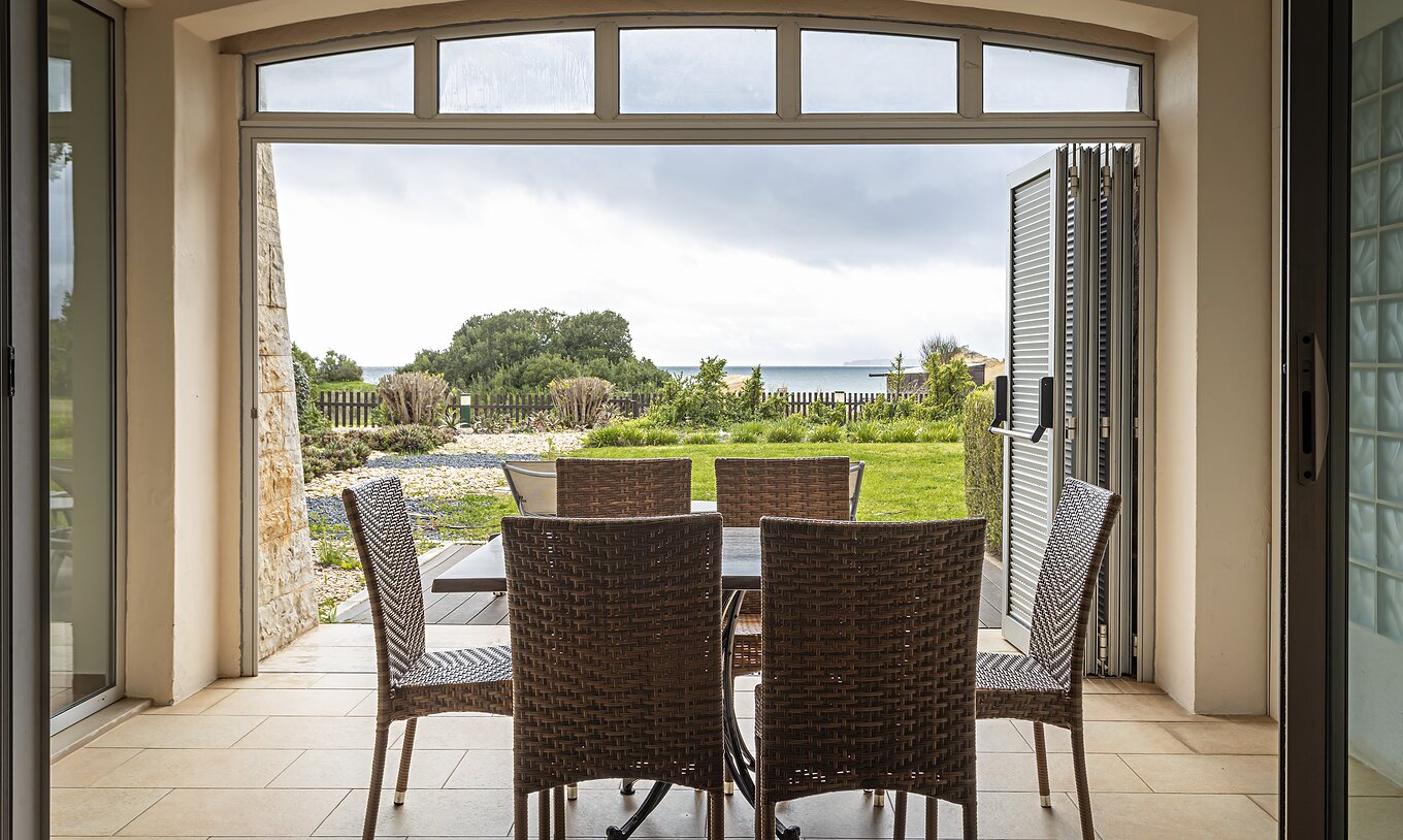 The Cliff Suite T2 at Pestana Alvor Praia has a porch with a table and chairs, and a garden with a view of the beach