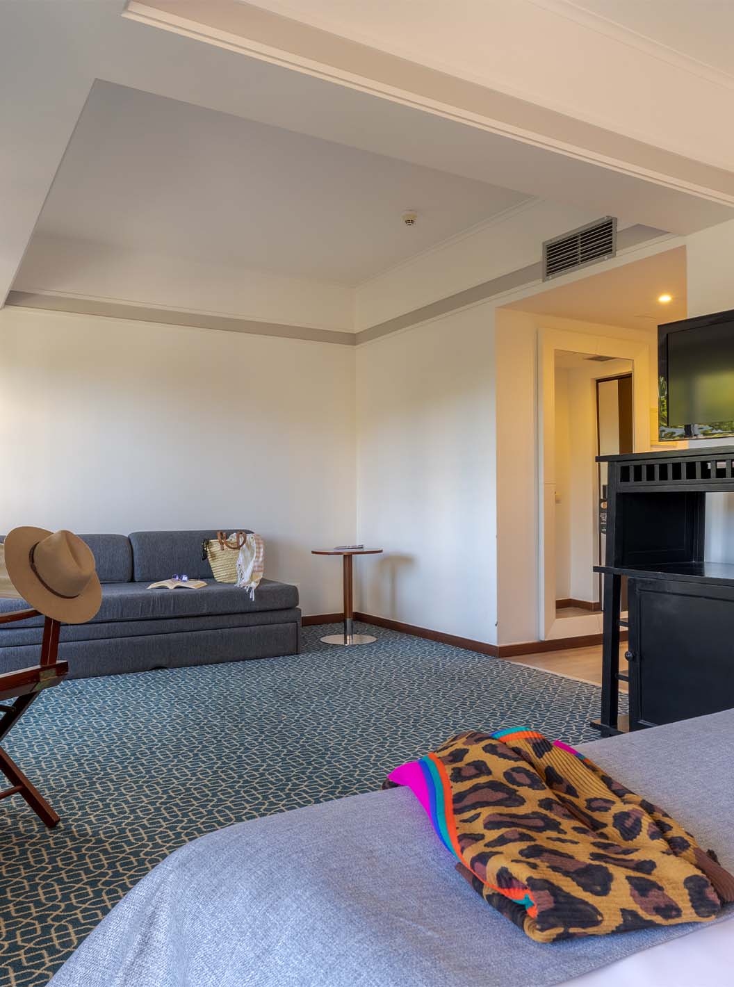 The Superior at Pestana Alvor Praia has a double bed, a black unit with TV, a sofa bed, and a desk