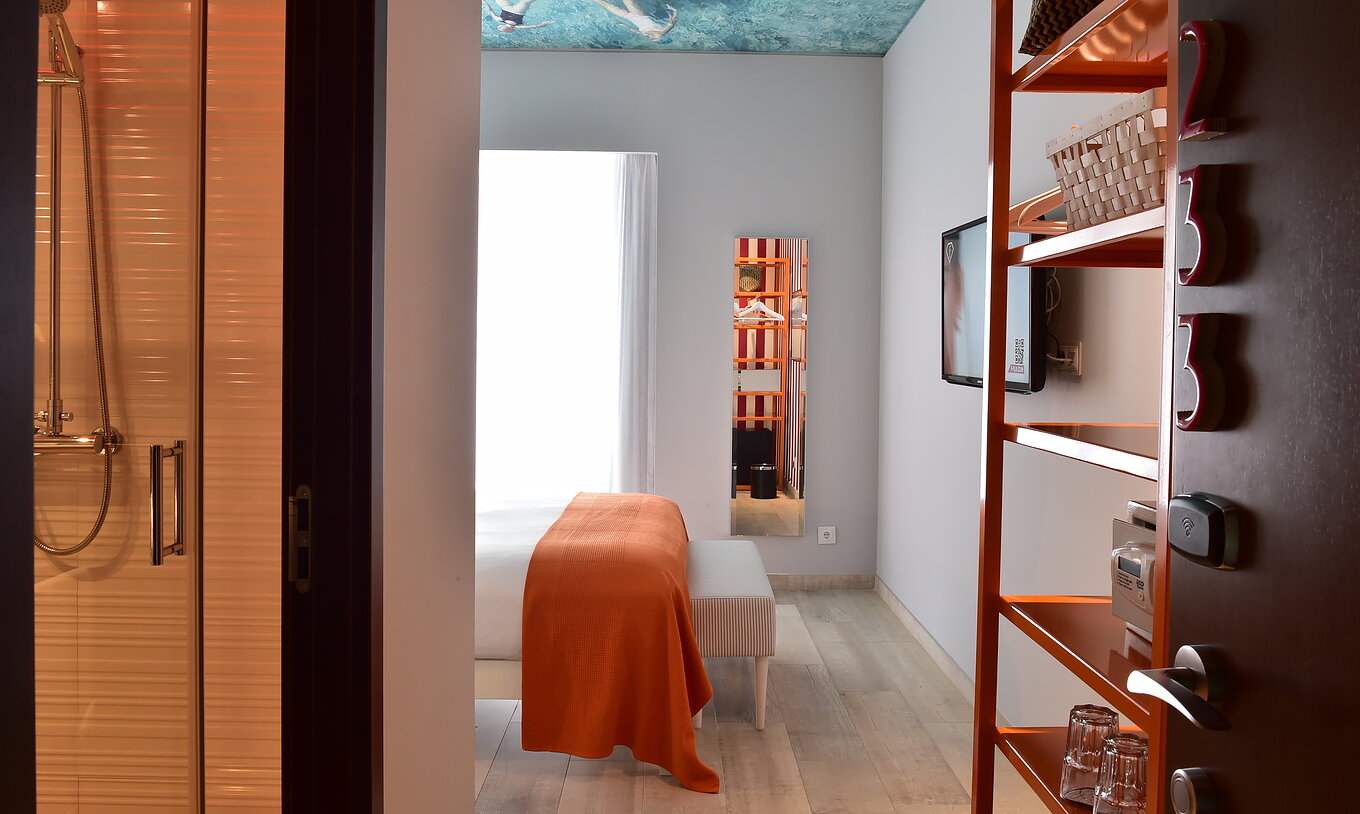 The Deluxe - Exclusive Website of Pestana Alvor South Beach has a small open wardrobe with hangers and shelves