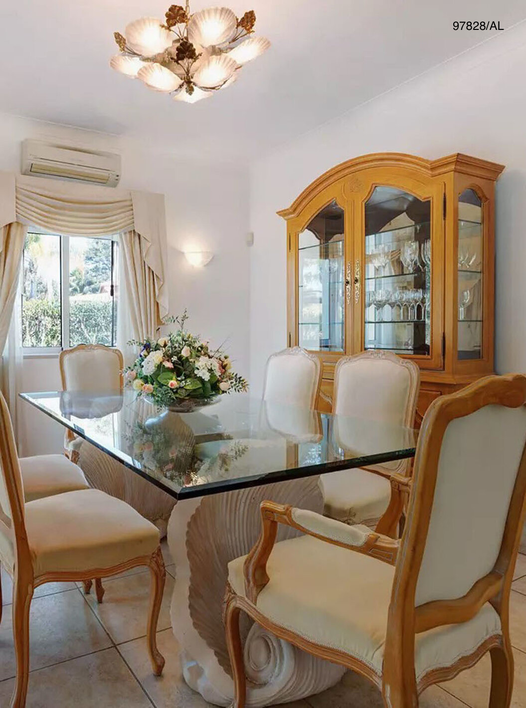 The Pestana Carvoeiro Golf V3 Standard Villa has a dining room with a glass table, chairs, and a cabinet