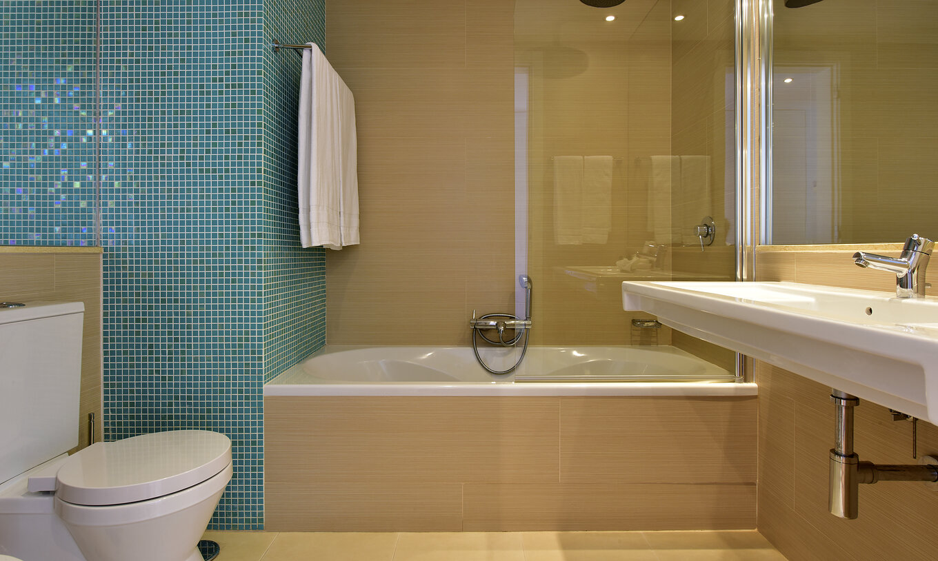 The Standard Suite at Pestana Dom João II includes a bathroom with a sink, mirror, and bathtub with shower