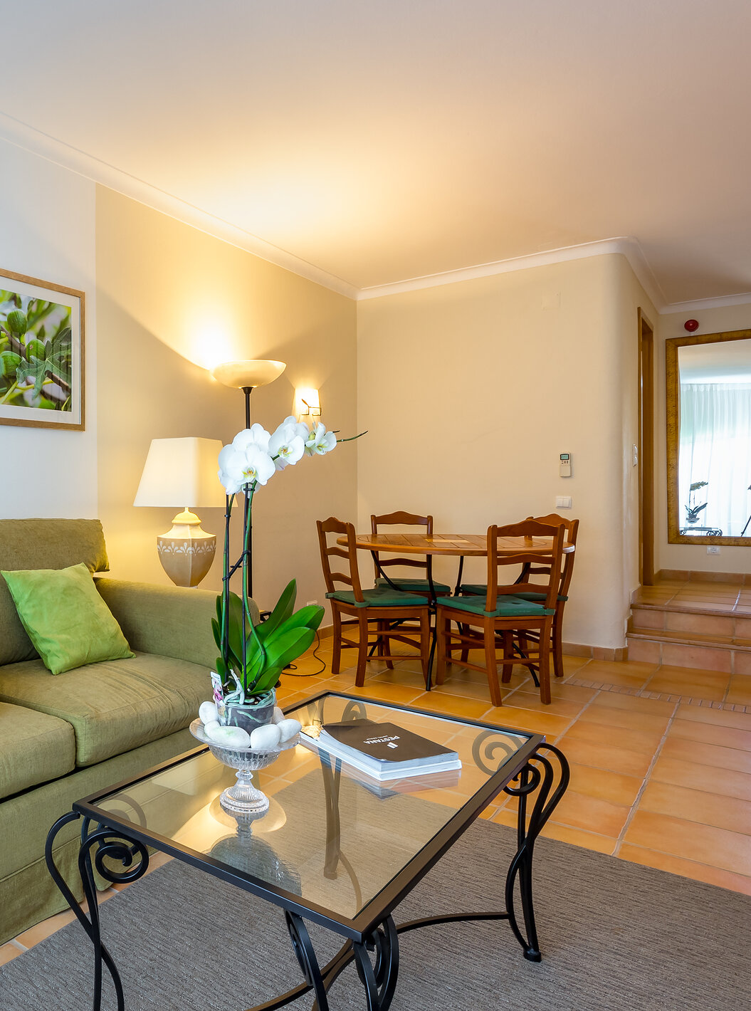 The T2 Apartment Standard do Pestana Palm Gardens has a living room with a sofa and cushions, a round table and paintings