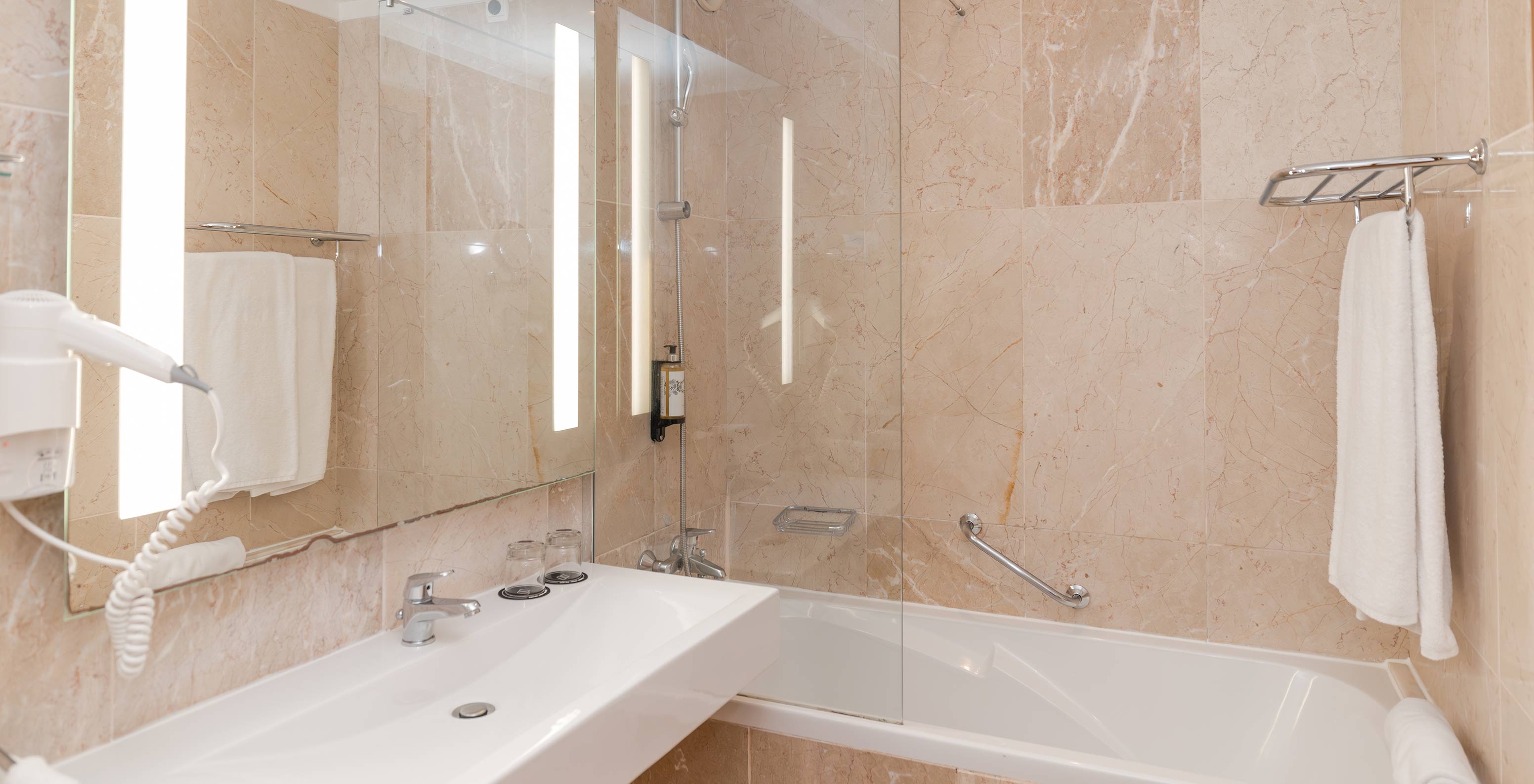 The Deluxe Garden View at Pestana Viking has a bathroom with sink, large mirror and bathtub with shower