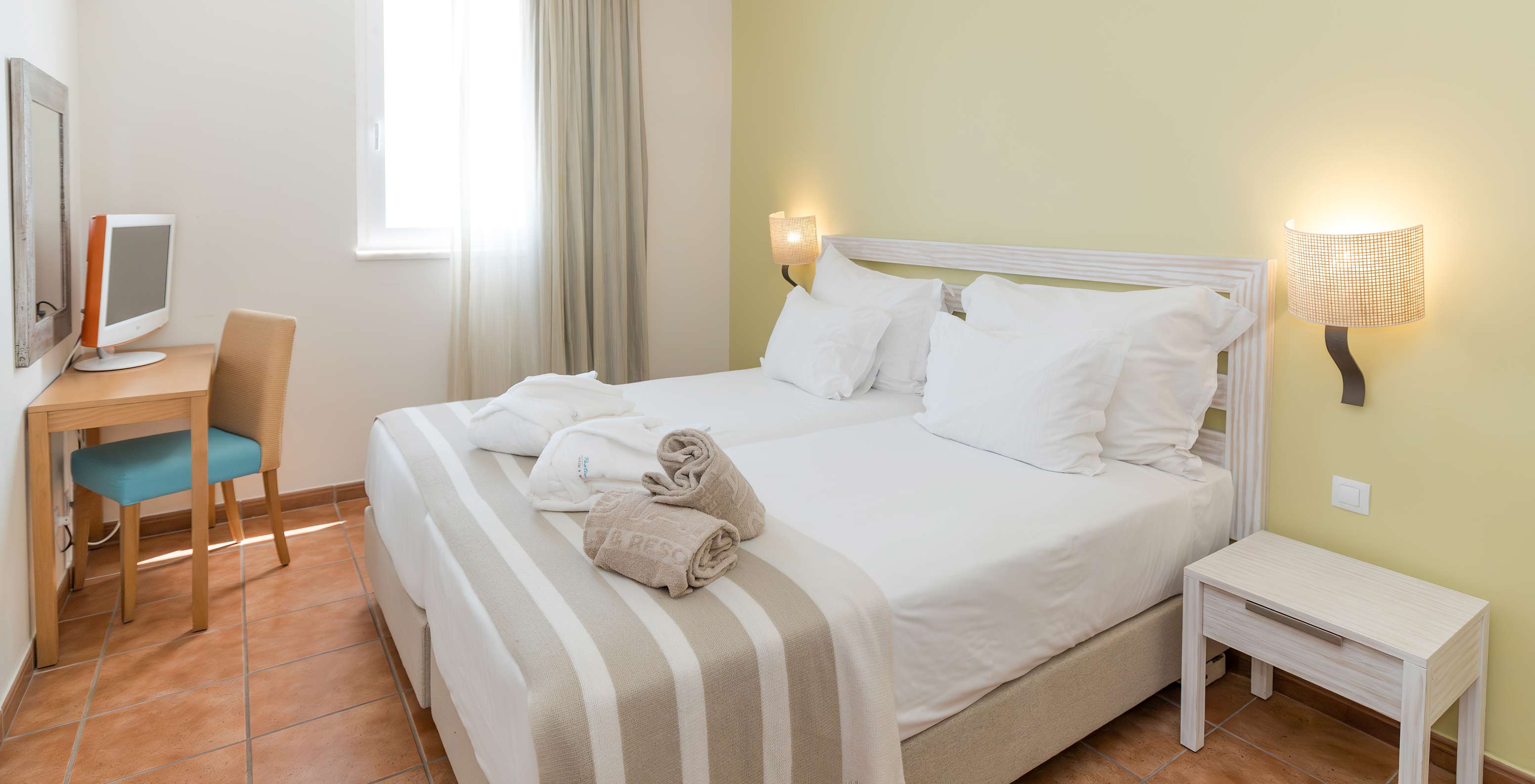 The Superior Sea View Suite at Pestana Viking features two single beds, bedside table, television, and mirror