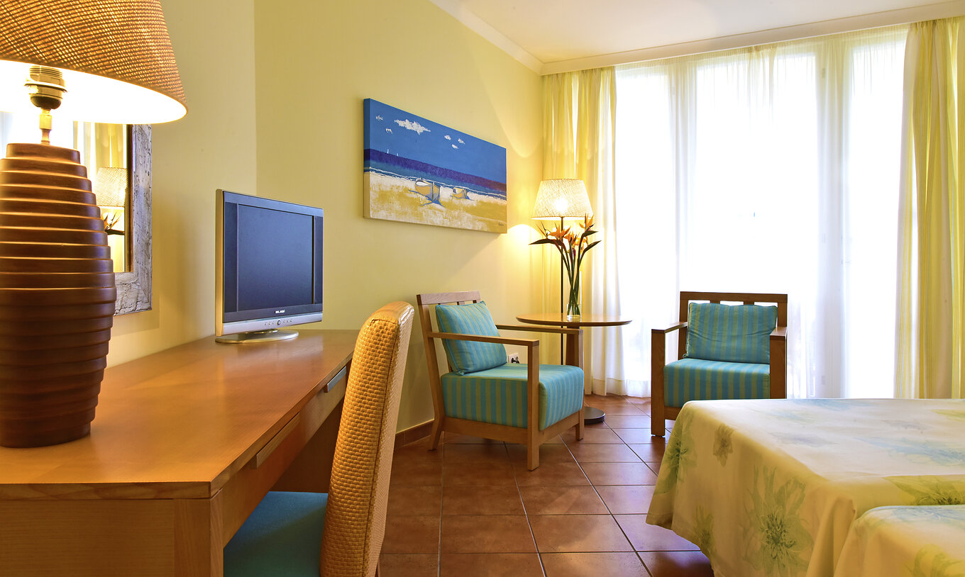 The Deluxe Superior Sea View room at Pestana Viking features television, two chairs with coffee table, and a desk