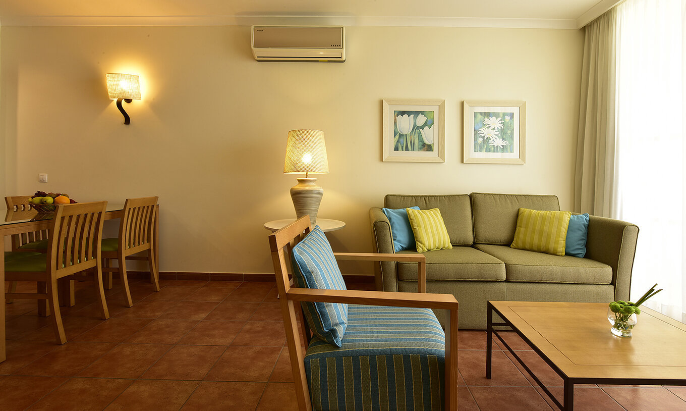 The Suite at Pestana Viking features a green sofa, a coffee table, an armchair, and a lamp