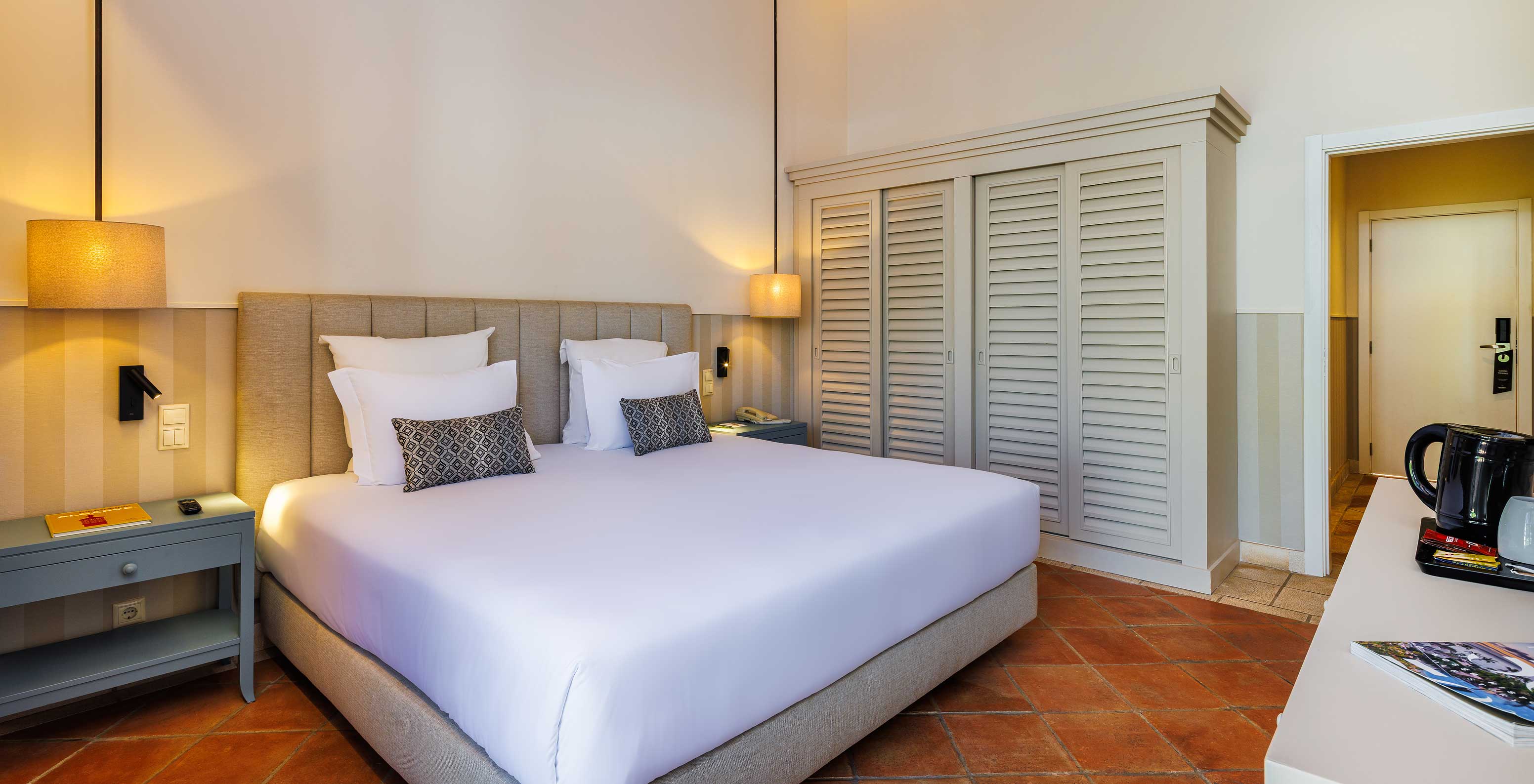 The Superior Garden View at Pestana Vila Sol - Vilamoura has a double bed with two nightstands and a large wardrobe