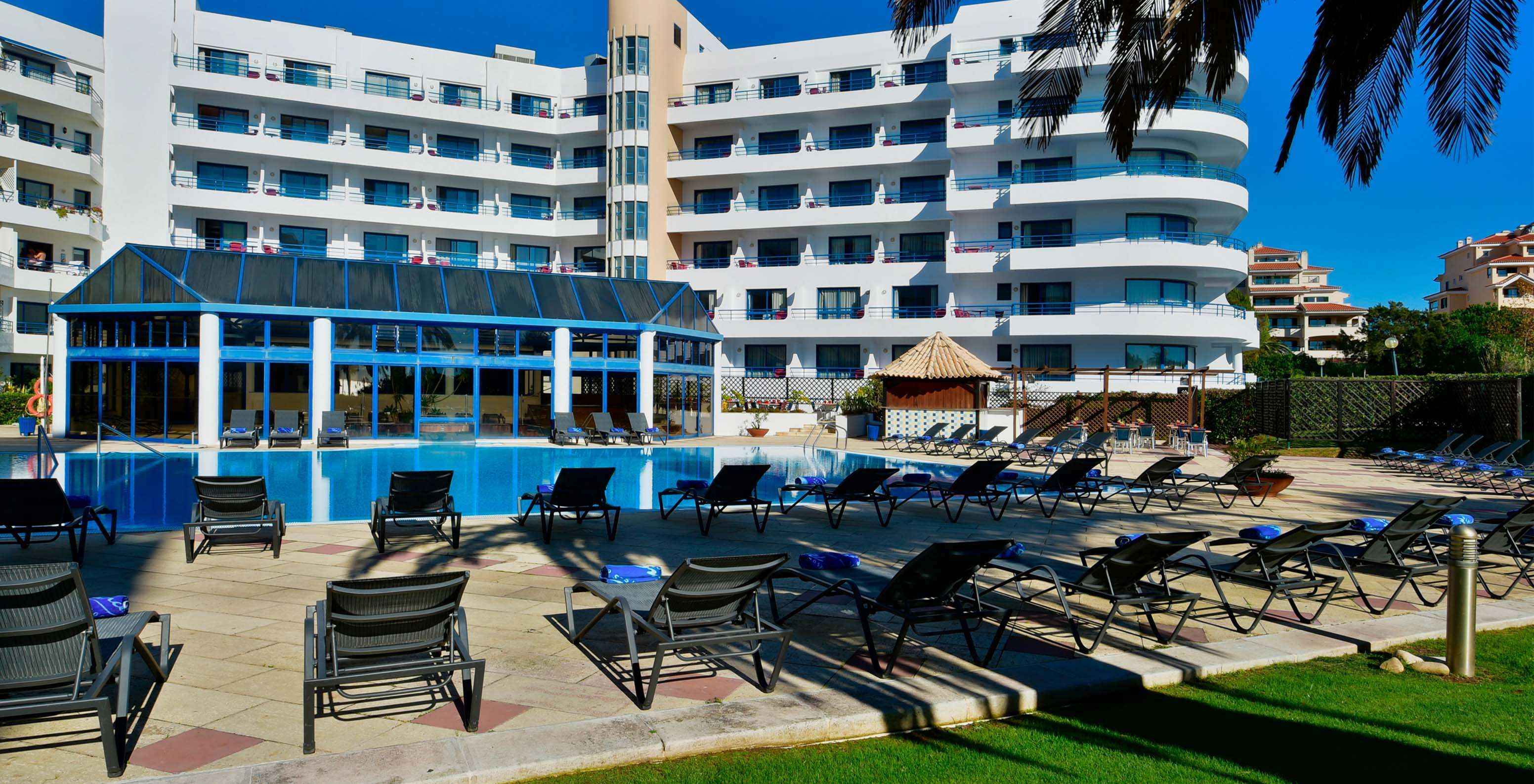 Pestana Cascais garden view towards outdoor pool, loungers, and pool bar
