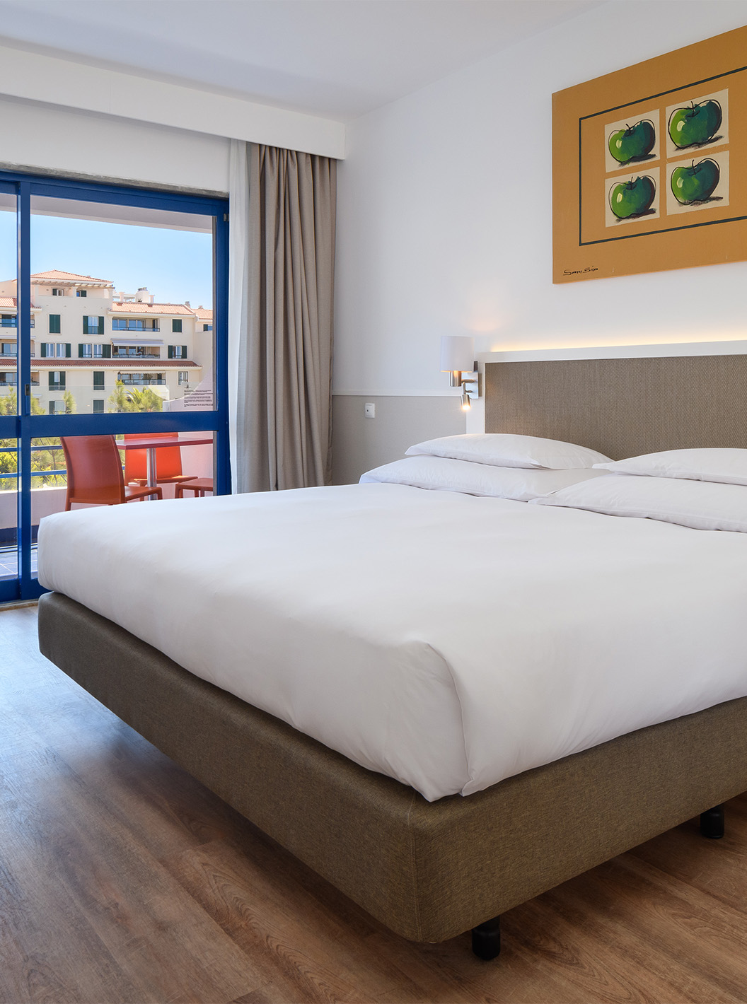 The Deluxe Suite at Pestana Cascais has a double bed, a desk, and a painted picture on the wall