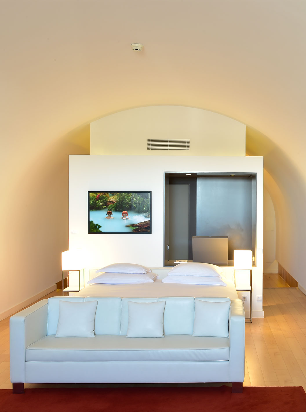 The Junior Suite Art District at Pestana Cidadela Cascais has a double bed with a white sofa and a painting on the wall