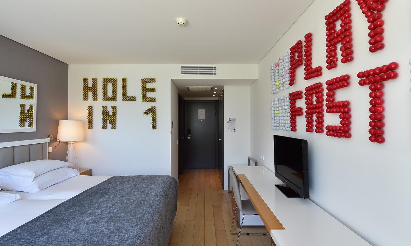 The Superior Room with Balcony at Pestana Cidadela Cascais has a hallway at the entrance, a TV, and art on two walls