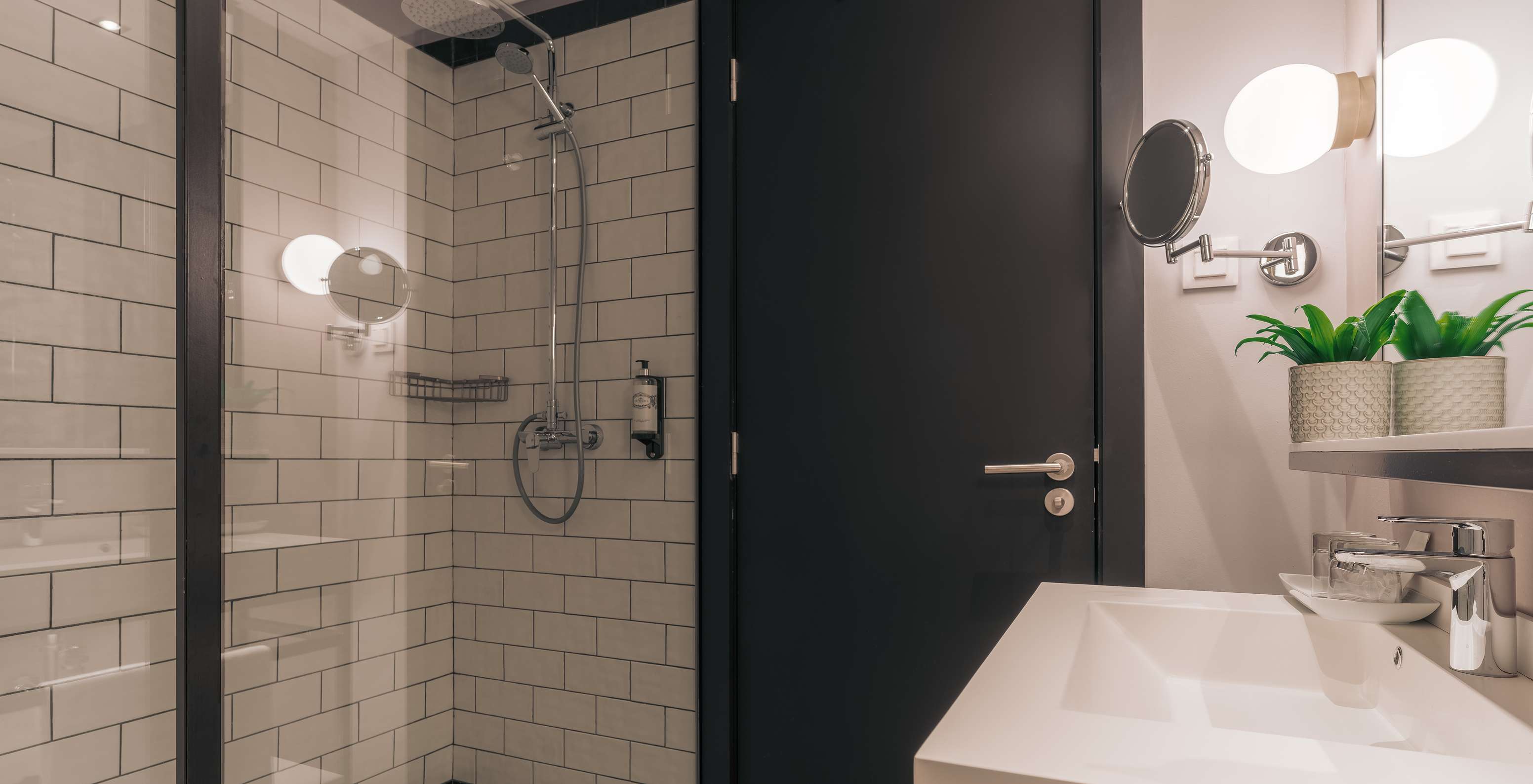 The Rooftop Junior Suite at Pestana Lisboa Vintage has a bathroom with shower with glass doors and two mirrors