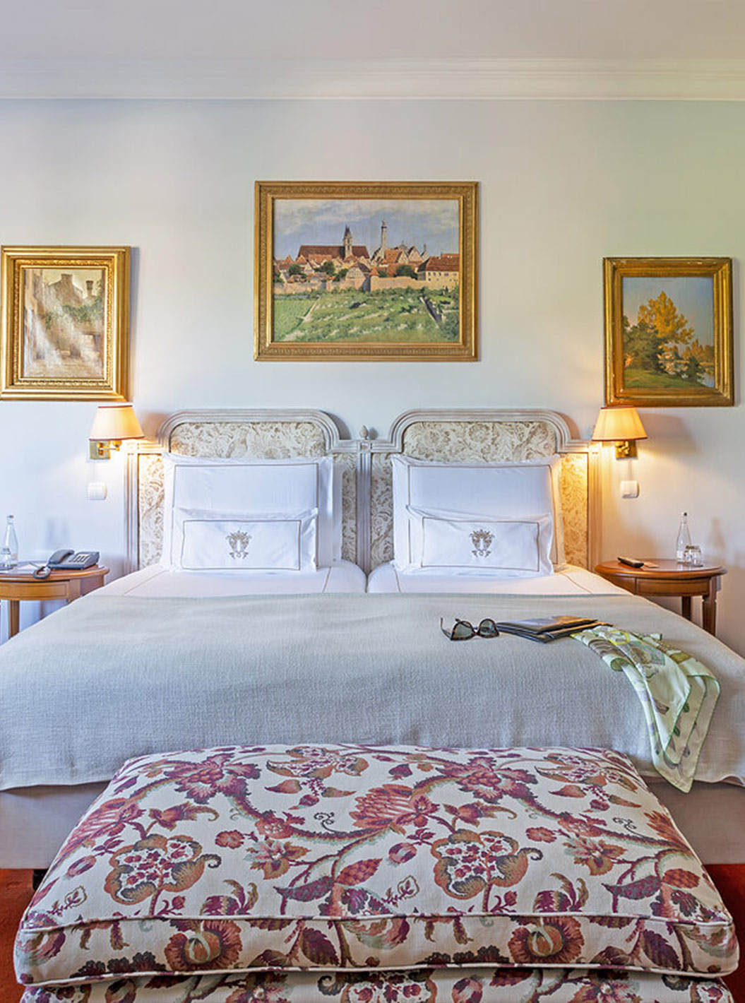 The Suite at Pestana Palace Lisboa has a double bed with a bench at the foot of the bed and a large wardrobe