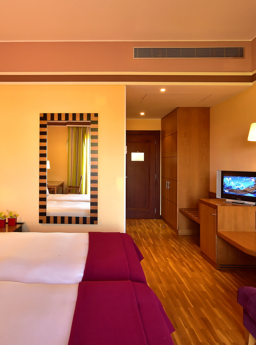 The Classic Double - Garden View of Pestana Sintra Golf has two beds, a mirror on the wall, a television, and a sofa