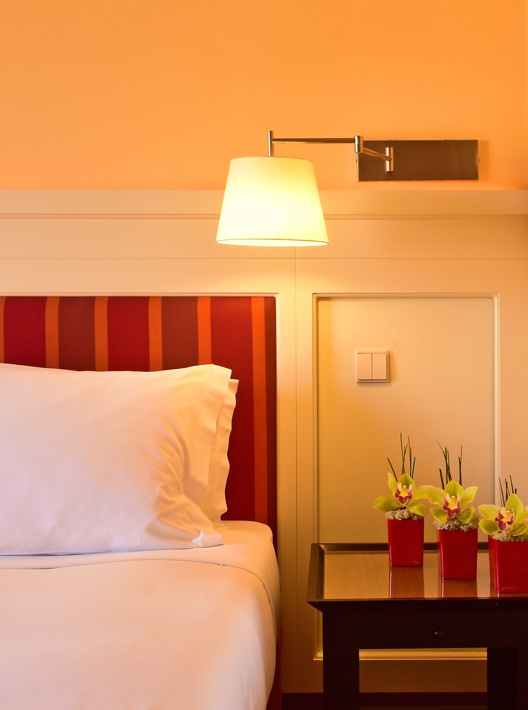The Classic Double of Pestana Sintra Golf has a bed, a mirror, a lamp, and a bedside table with flowers