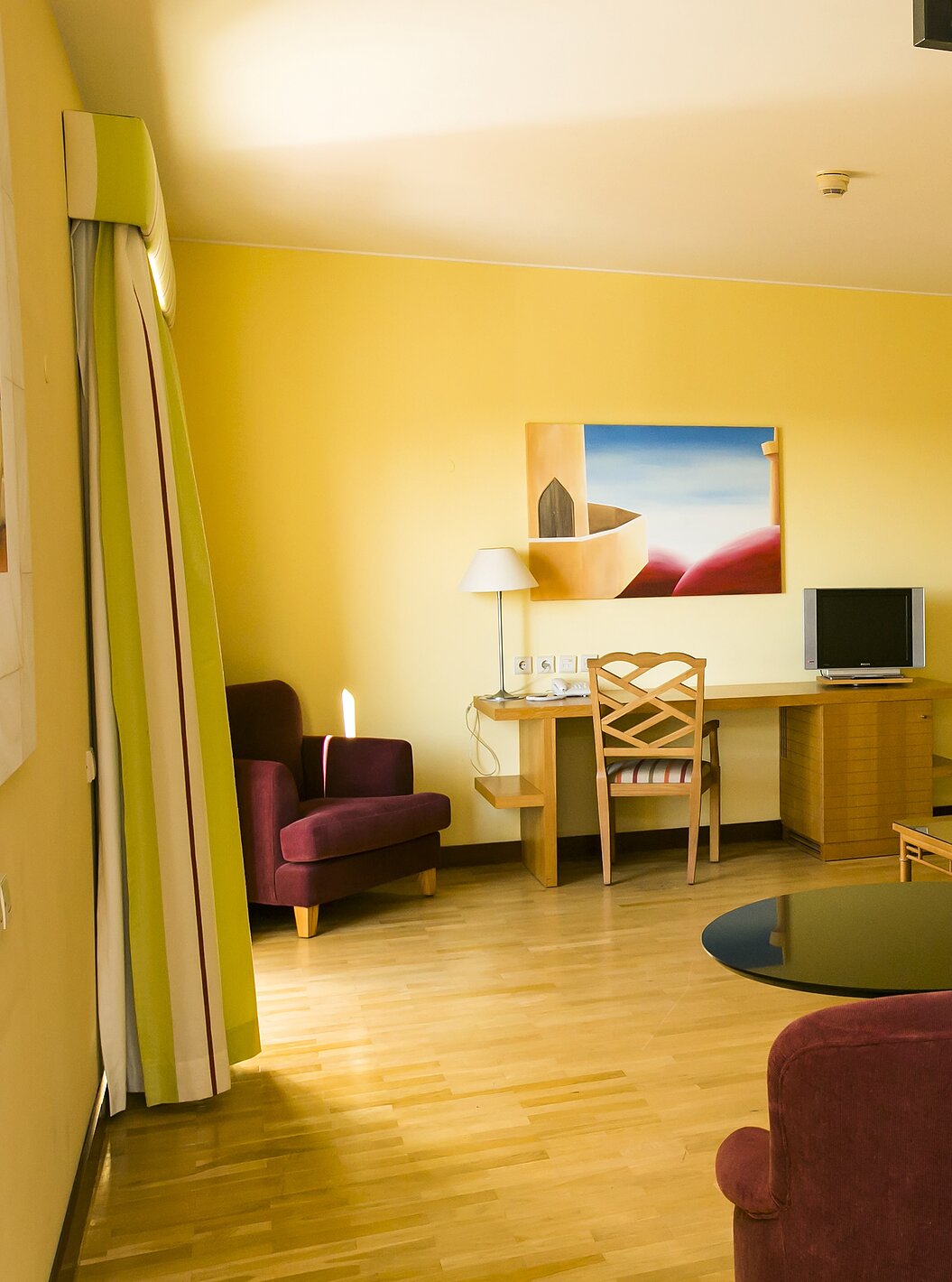 The Deluxe Mezzanine Suite of Pestana Sintra Golf has a room with sofa, armchairs, television, and a picture on the wall