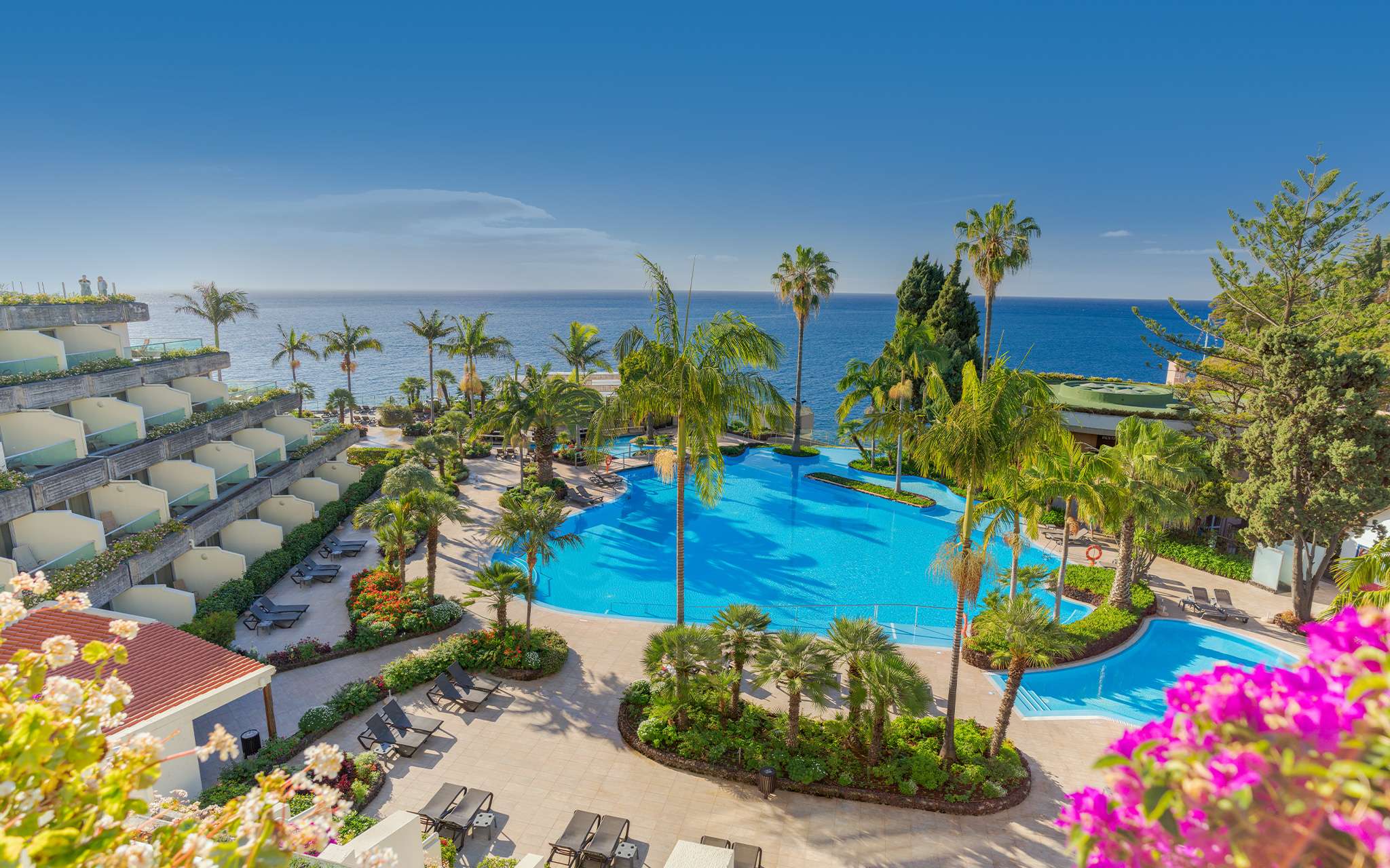 Exterior view of the pool and building of Pestana Carlton, a hotel in the center of Funchal facing the sea