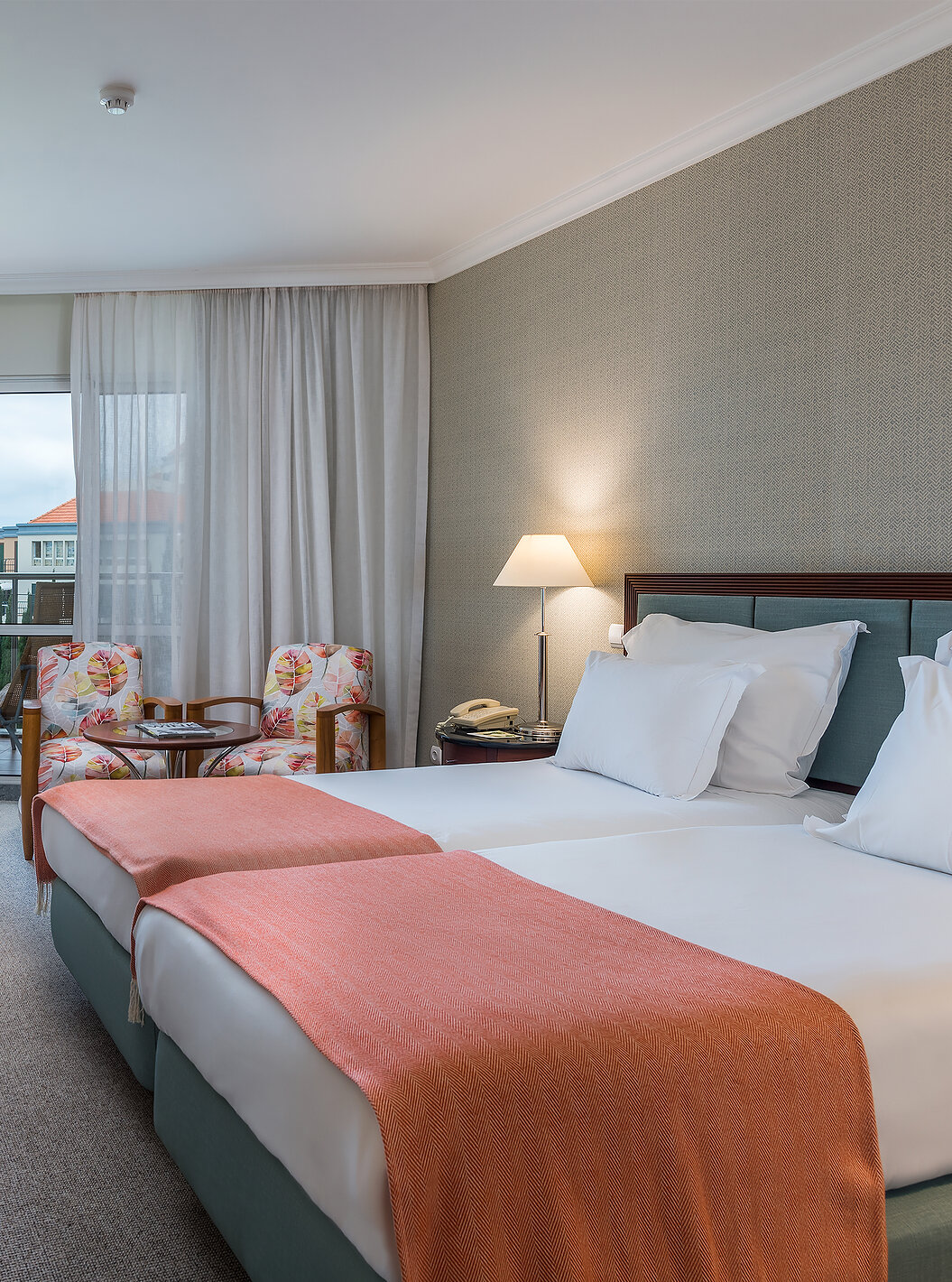 The Classic Sea Side Room at Pestana Grand has two single beds with bedside table, two armchairs