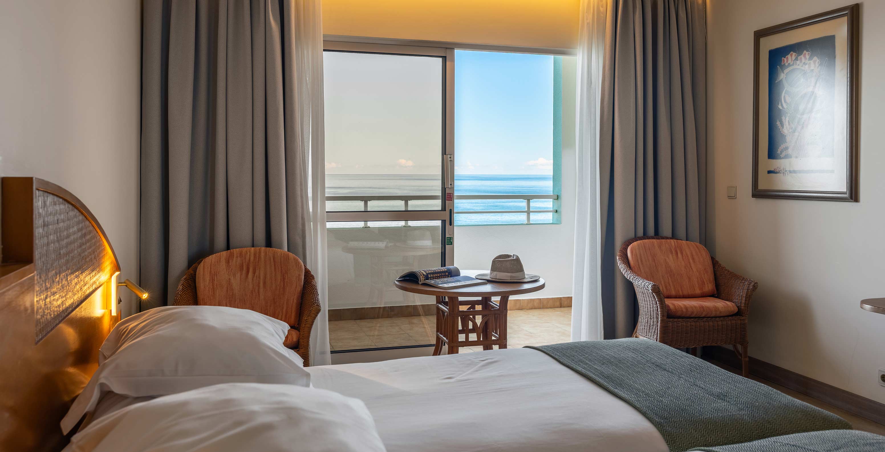 The Pestana Ocean Bay All Inclusive Classic Sea View has a double bed, two chairs, and a balcony with sea view