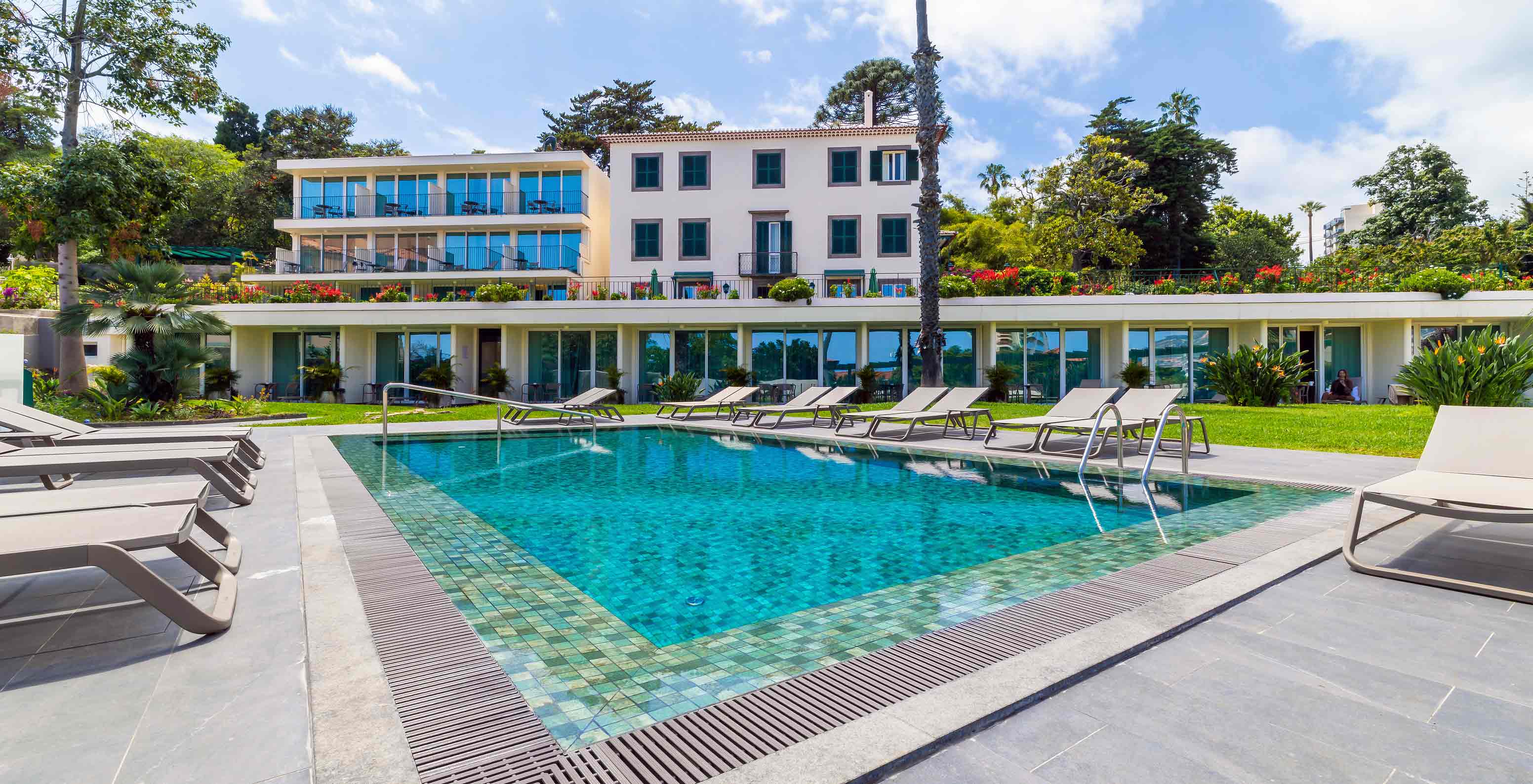 Facade of Pestana Quinta Perestrello Hotel overlooking the pool and sun lounger area