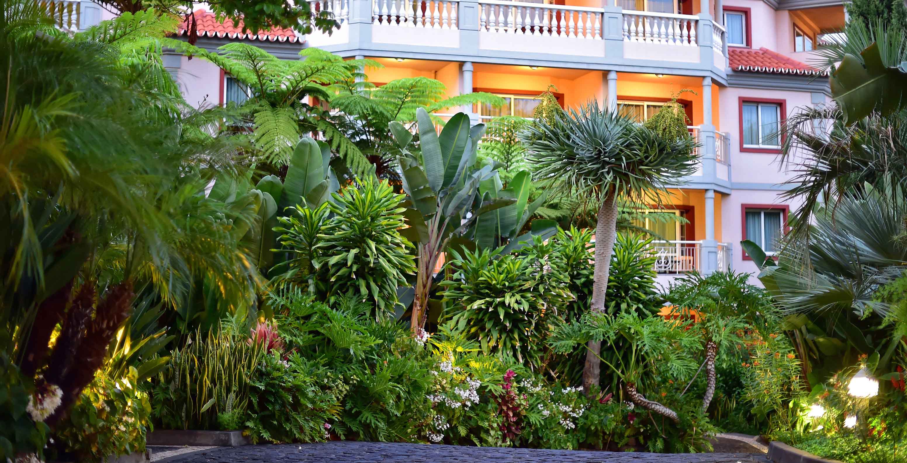 Facade of a multi-storey building at Pestana Village with a tropical garden in front of the balconies