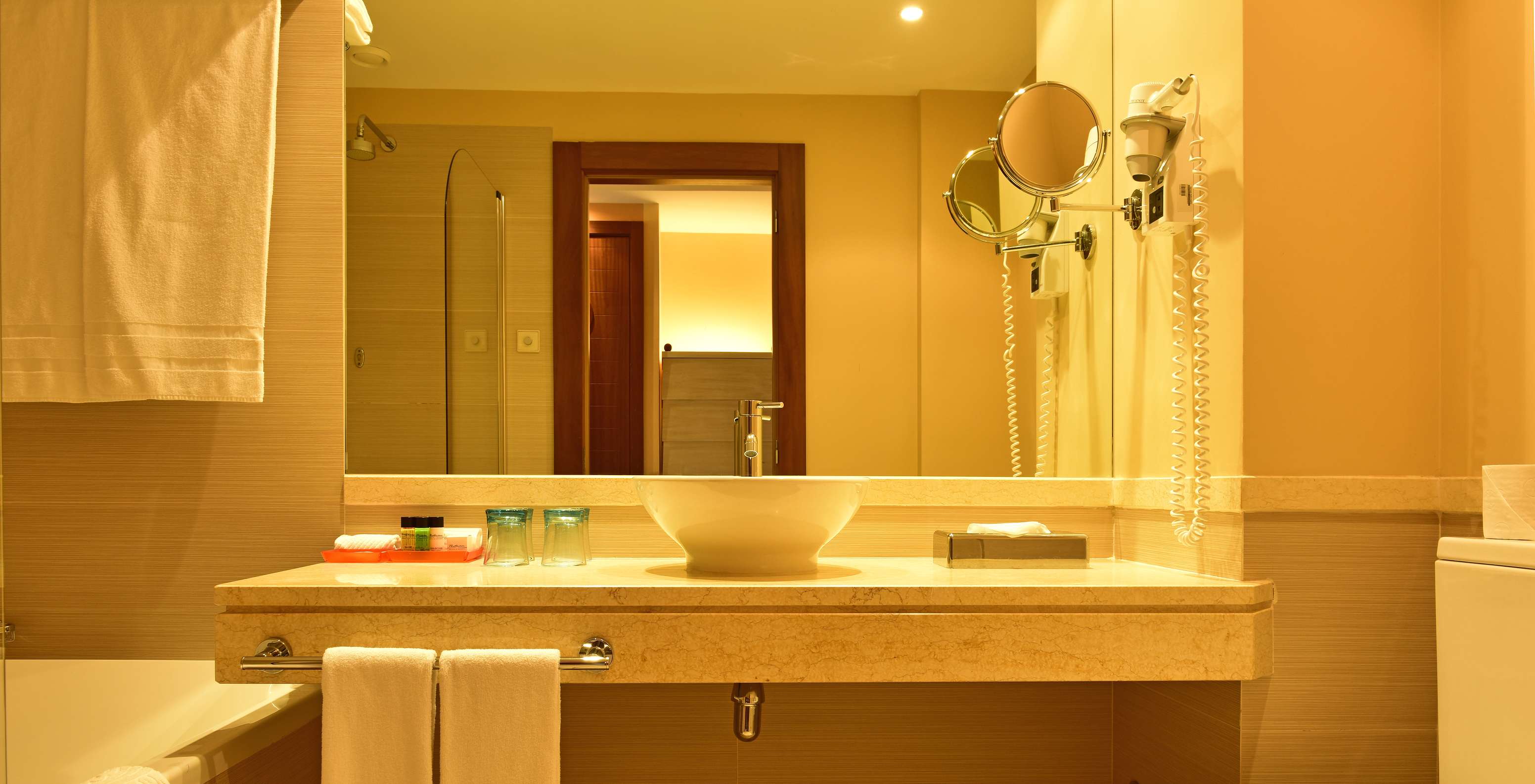 The Classic Double of Pestana Porto Santo All Inclusive has a bathroom with sink, mirror, toilet, and towels