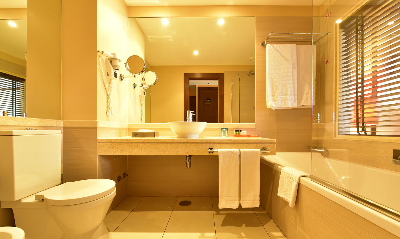 The Family Double of Pestana Porto Santo All Inclusive has a bathroom with bathtub, window, and sink with mirror